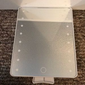 A white stand up vanity mirror, lights up